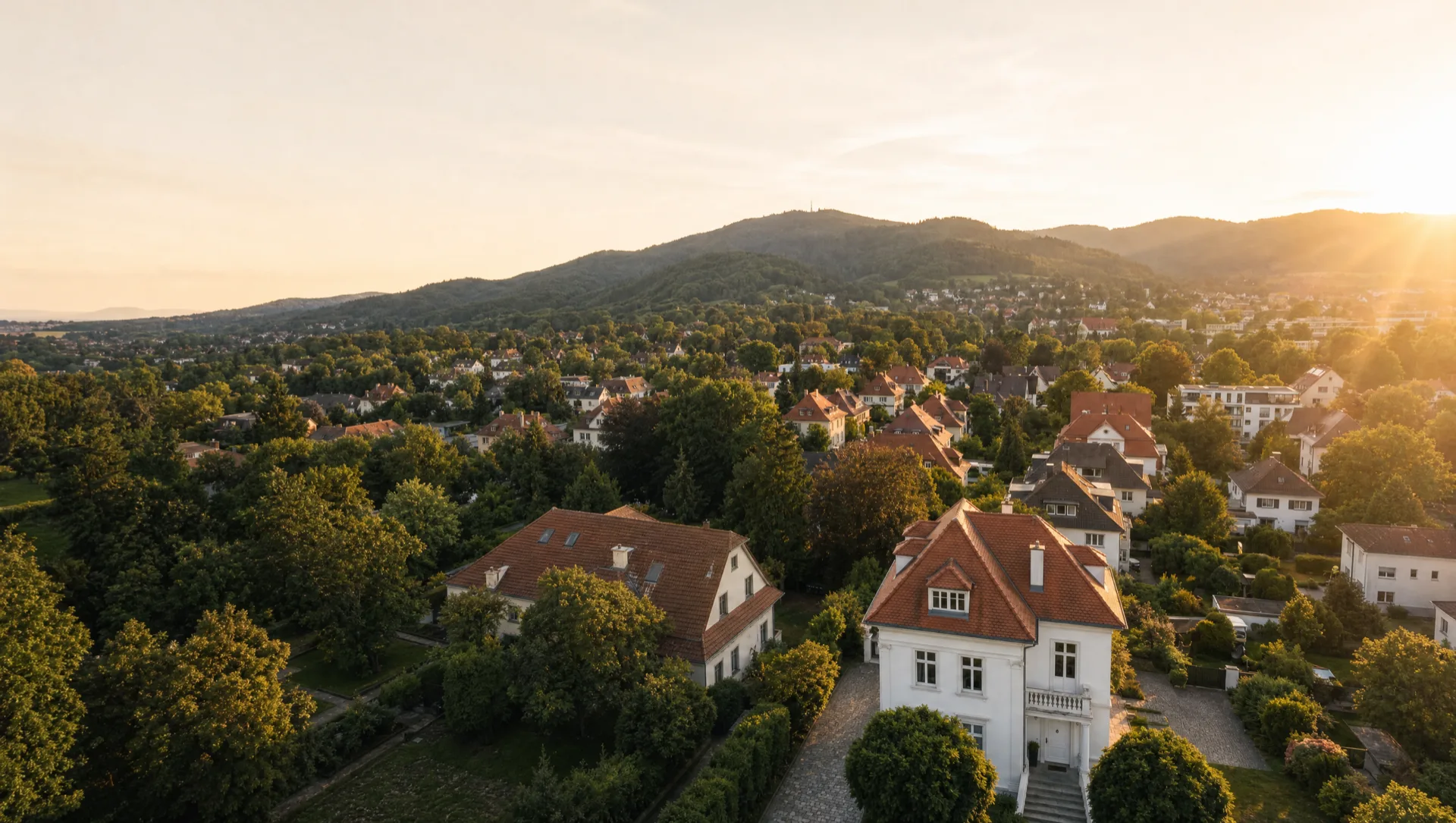 Wohnlage am Freiburger Hang im Abendlicht, Villa mit Ziegeldach im Vordergrund
